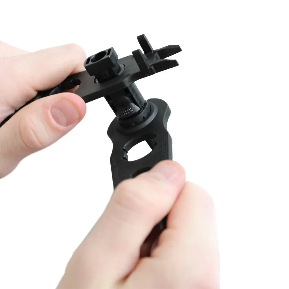 Hands gripping a solar connector gland nut with two Renogy MC4 assembly tools