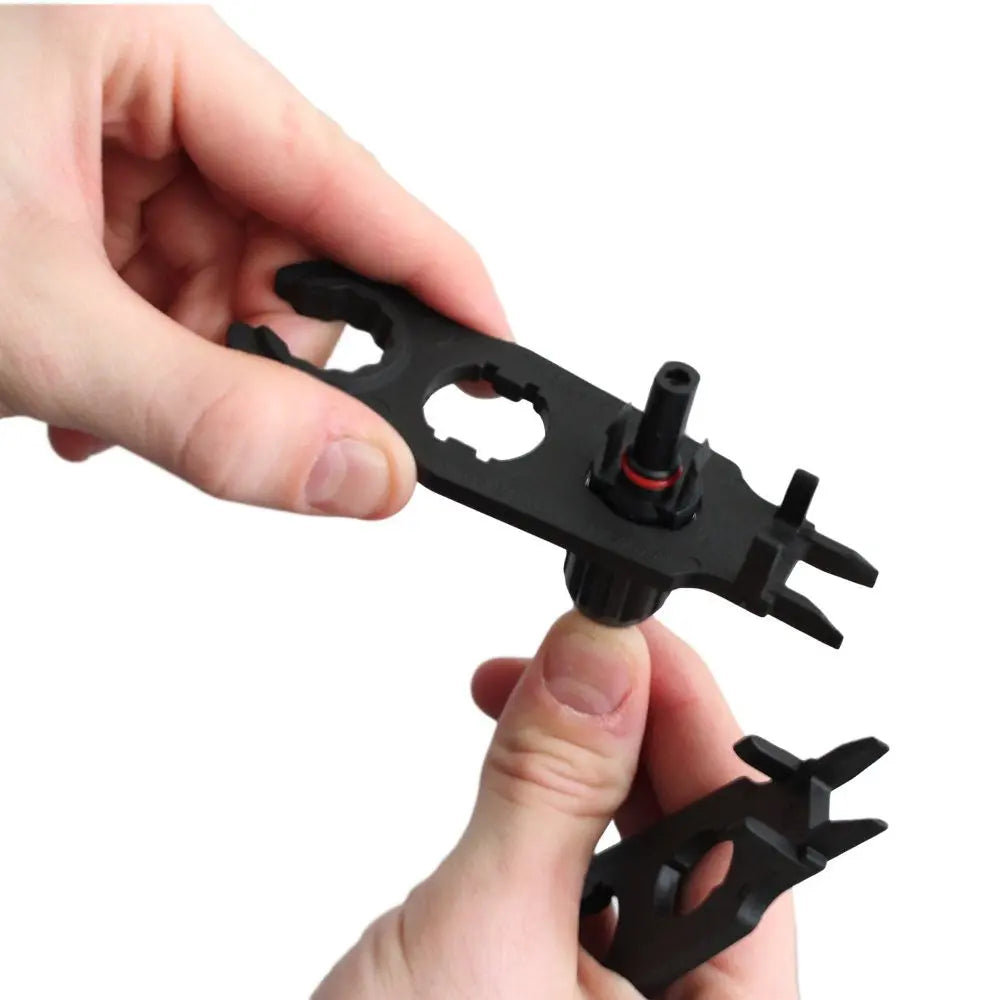 Hands holding two Renogy MC4 assembly tools with a solar connector body