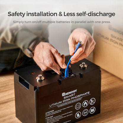 Person fastening a blue cable to a Renogy self-heating lithium battery terminal